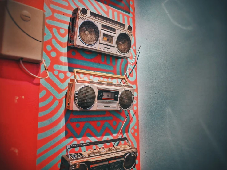 three boomboxes mounted on the wall beside each other