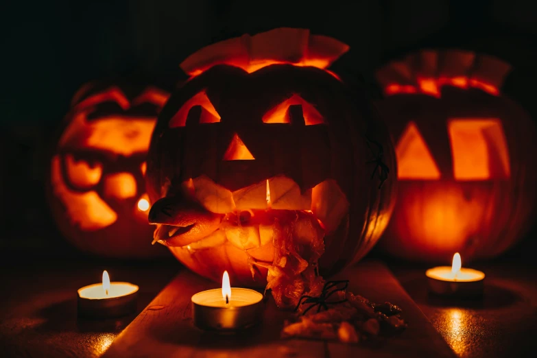 some jack o lanterns and candles are lit up in front of them