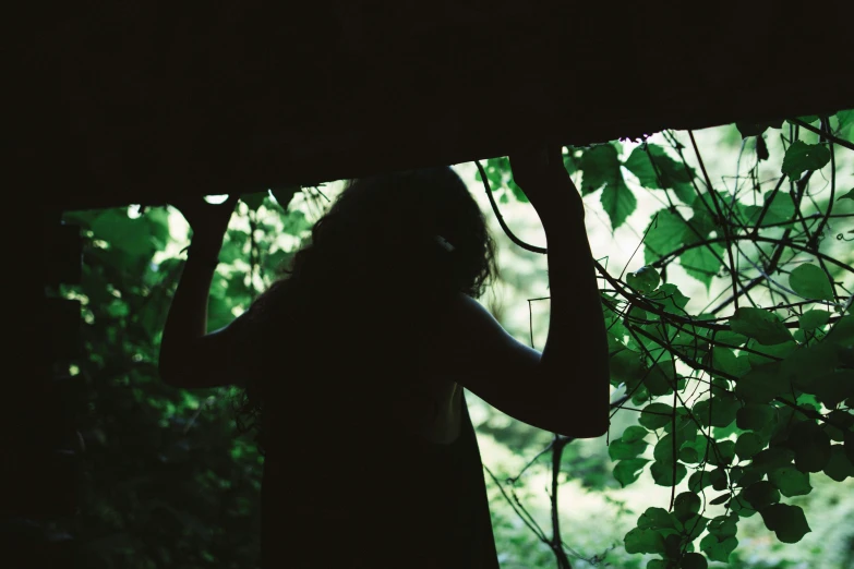 the woman is walking in the woods carrying her umbrella