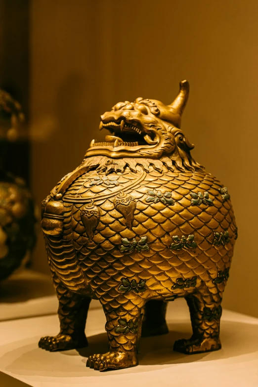 a gold decorated animal on a stand in the room