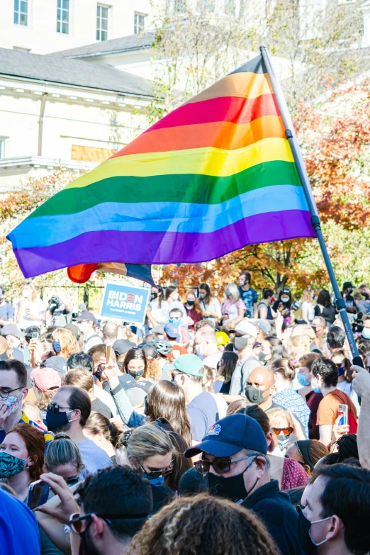 many people holding up a large colorful flag