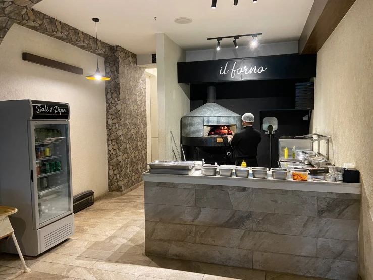 the interior of a restaurant with a marble counter and gray refrigerator