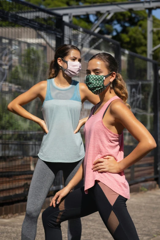 two women wearing face masks with one another