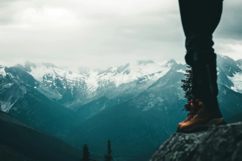 a pair of legs resting on top of a rock