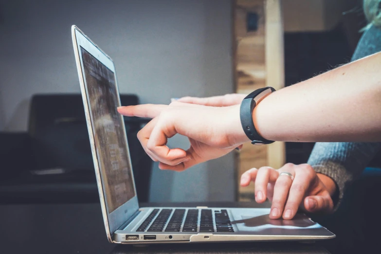 someone pointing their finger at a laptop