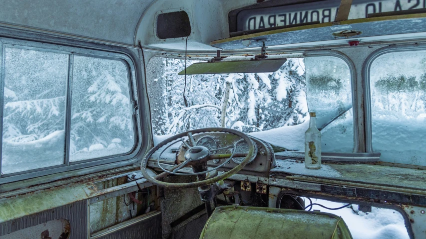 an old bus with some snow out of the windows