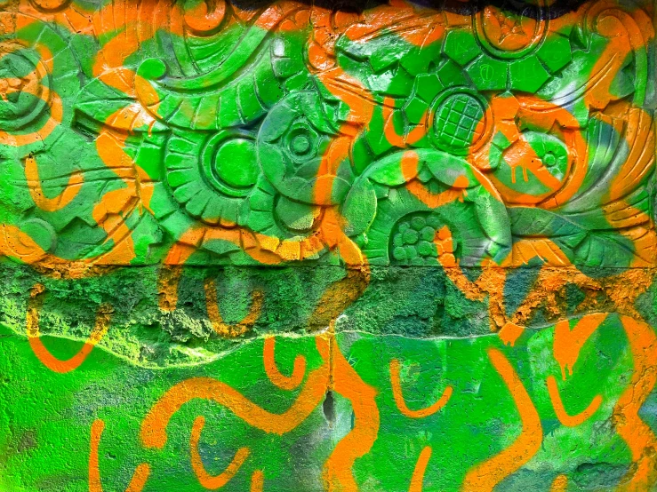 a close up of an orange and green artwork