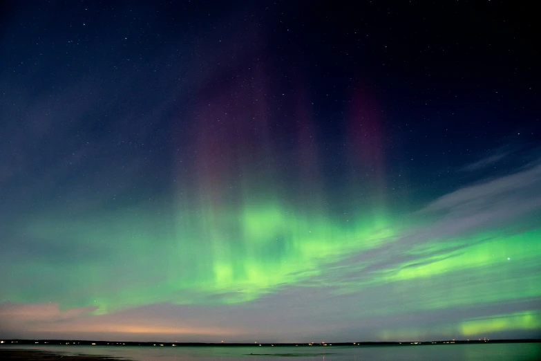 a green aurora display over the water