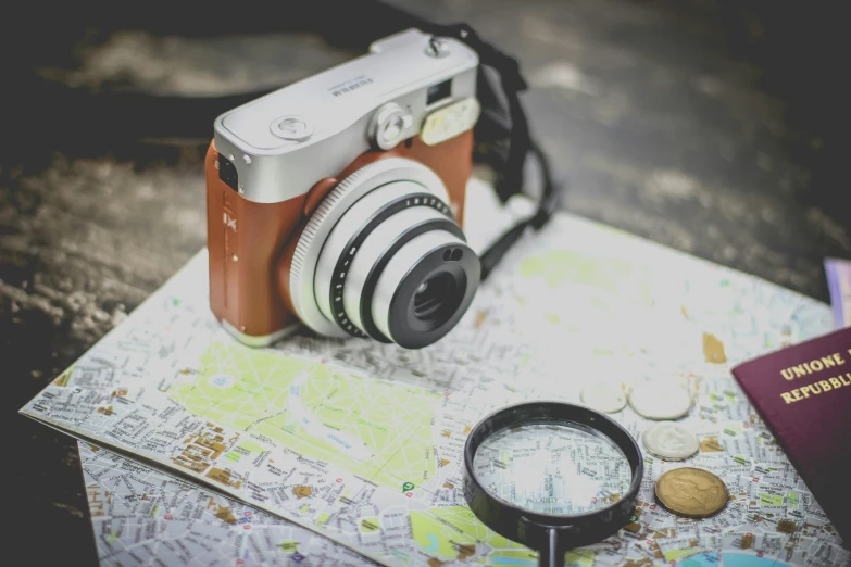 a camera, passport and magnifying glass resting on a table