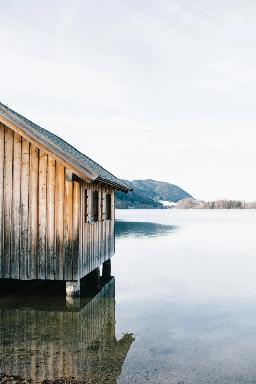 a hut on top of a body of water next to mountains