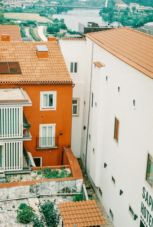 a town with red tile on the roofs and water in the background