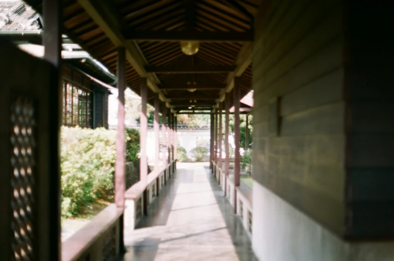 a walkway next to a building under a roof