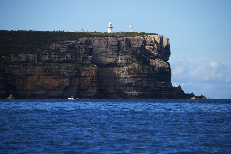 a lighthouse on top of a cliff above the ocean