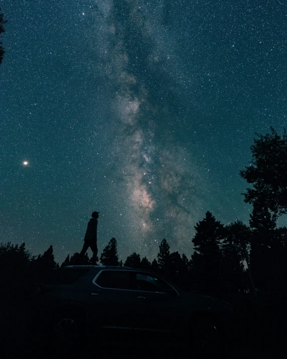 a person standing in the dark with the night sky