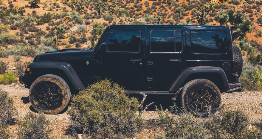 a black jeep is driving in the desert