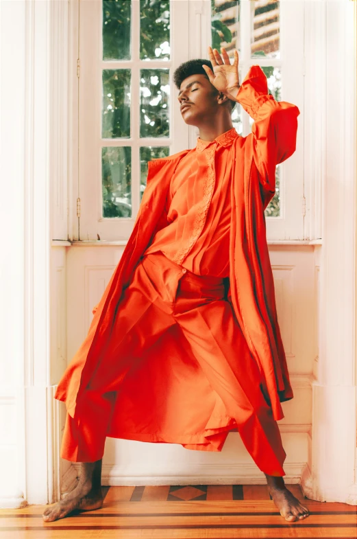 a person is in a room wearing an orange robe