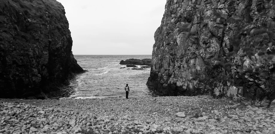 the person stands in the water between two large rocks