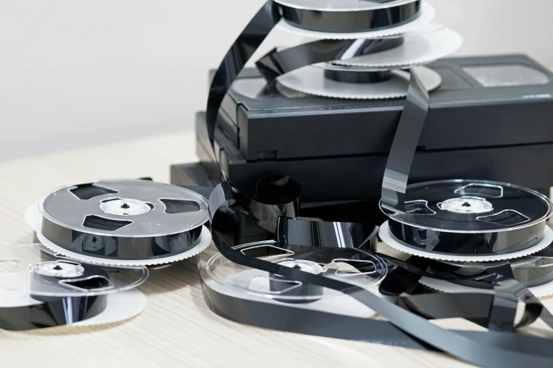 a table topped with black plastic reels and cd disks