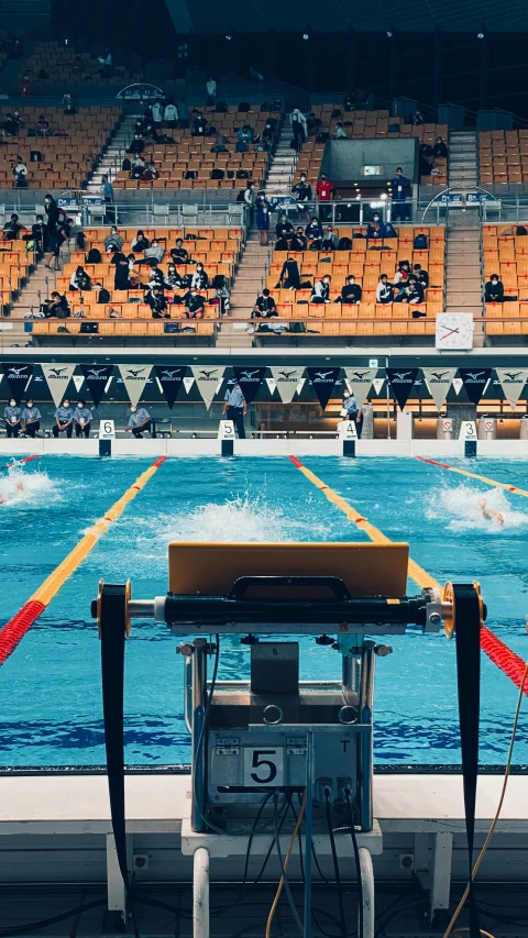 an olympic swimming pool with chairs and a swimming machine