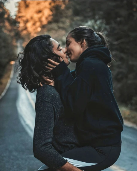 a couple in the middle of a road kissing