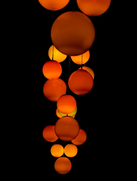 colorful lights hanging from a ceiling with oranges