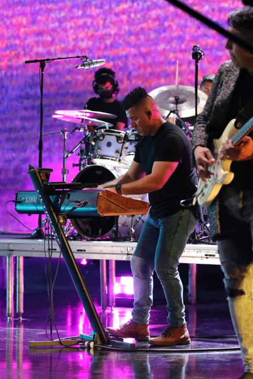 the men are singing on stage during the concert