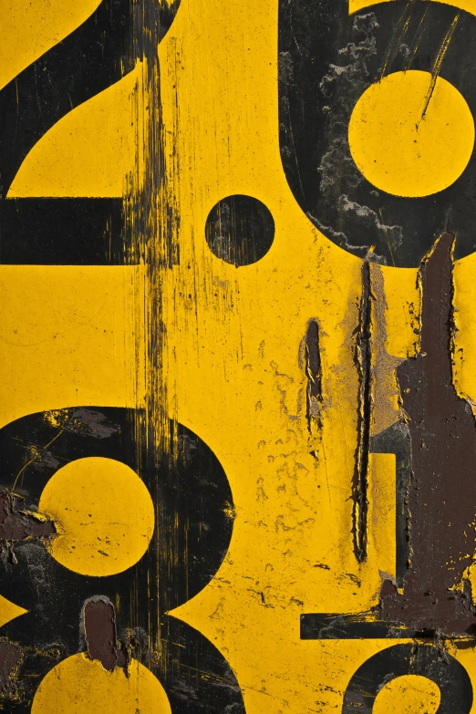 an old yellow and black sign with numbers