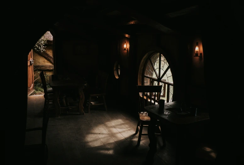 a dark house has an arched door and table in it