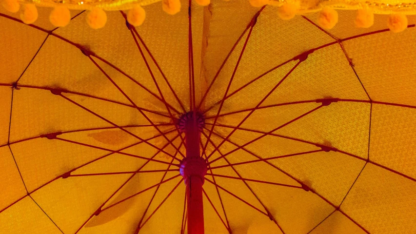 a po of an open umbrella with red lighting behind it