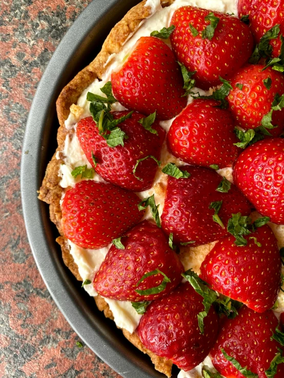 a strawberry cheesecake in a pan with fresh strawberries on top