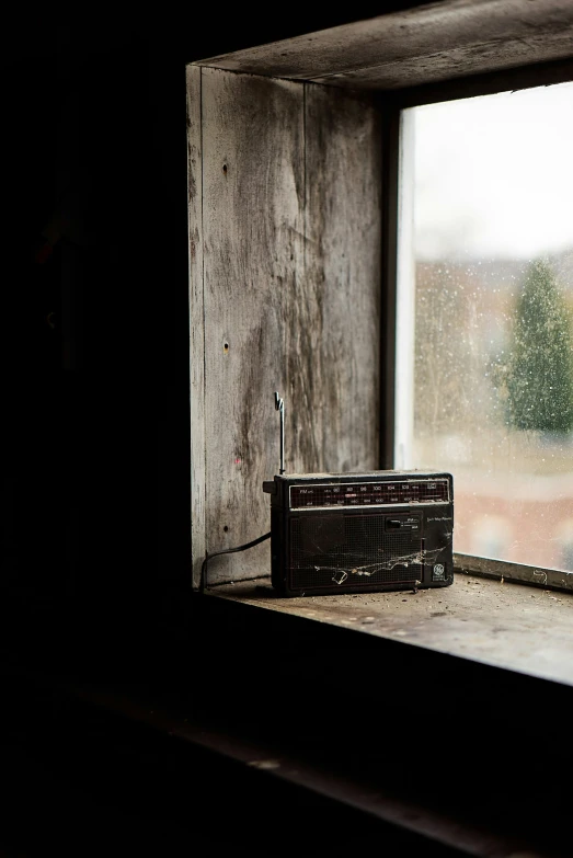 a radio is by a window with water outside