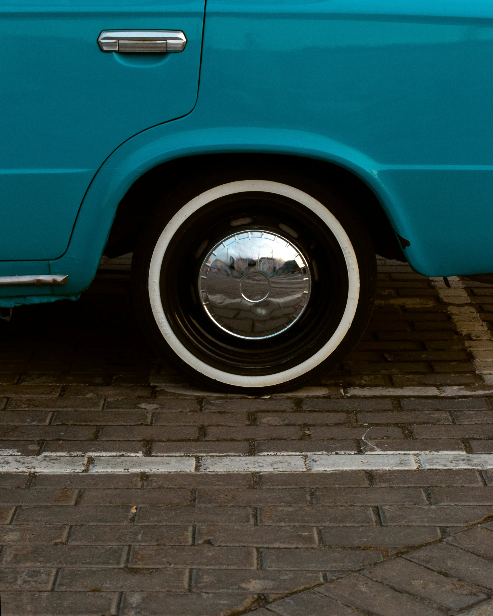 an older car parked on the brick road