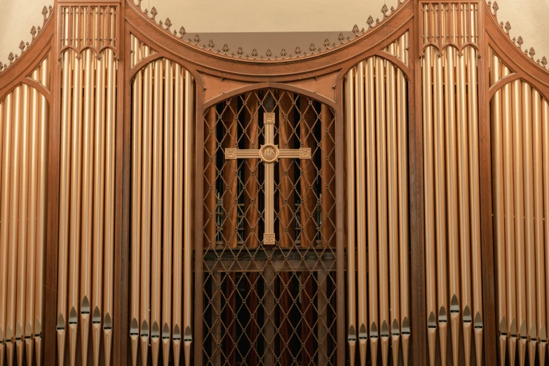 a large pipe organ with a cross mounted on it