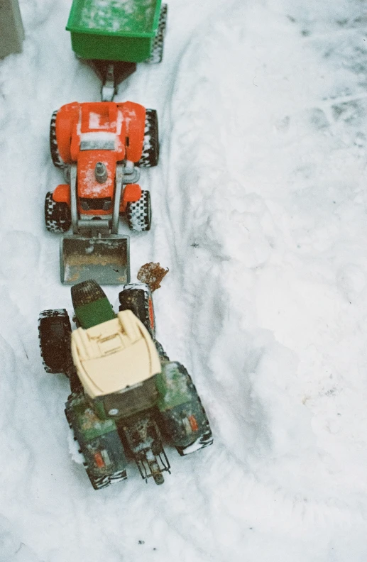 some trucks are parked in the snow in one direction