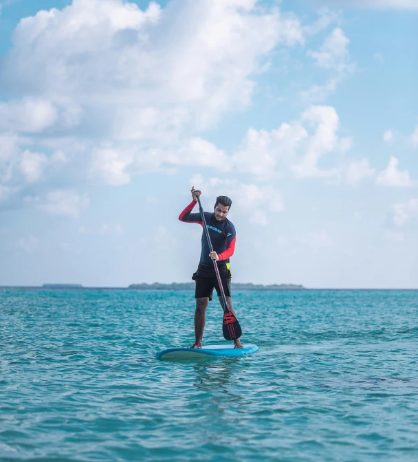 a man riding on top of a blue board in the ocean