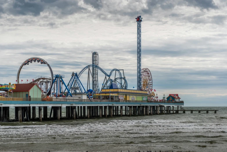 several rides on an amut park next to a large body of water