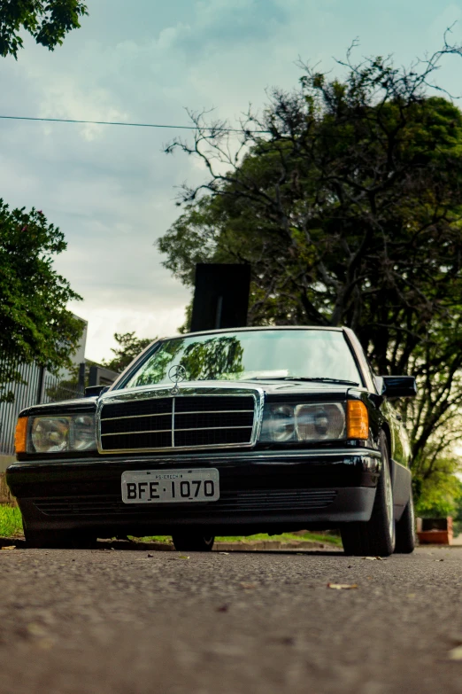 a car parked in the street with a fence in the background