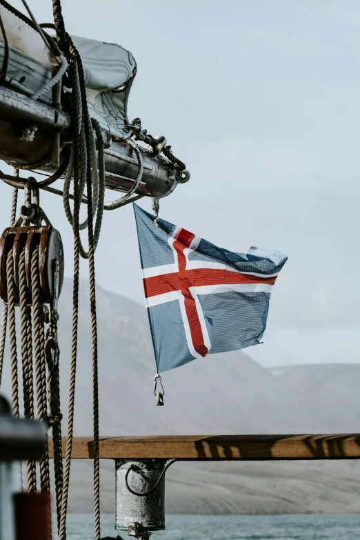 the flag is hanging on a boat in the water