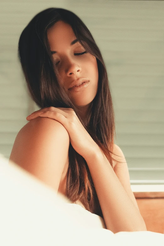 a beautiful young woman laying in a bed