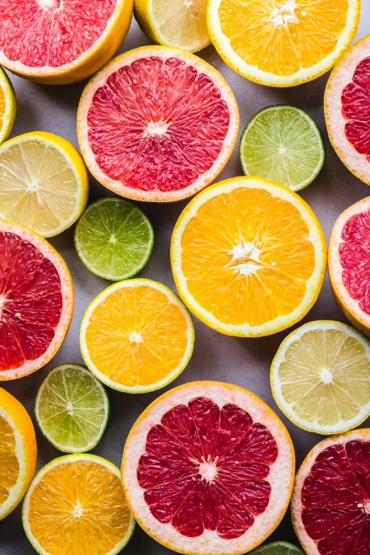 sliced oranges, limes and gfruit are laid out