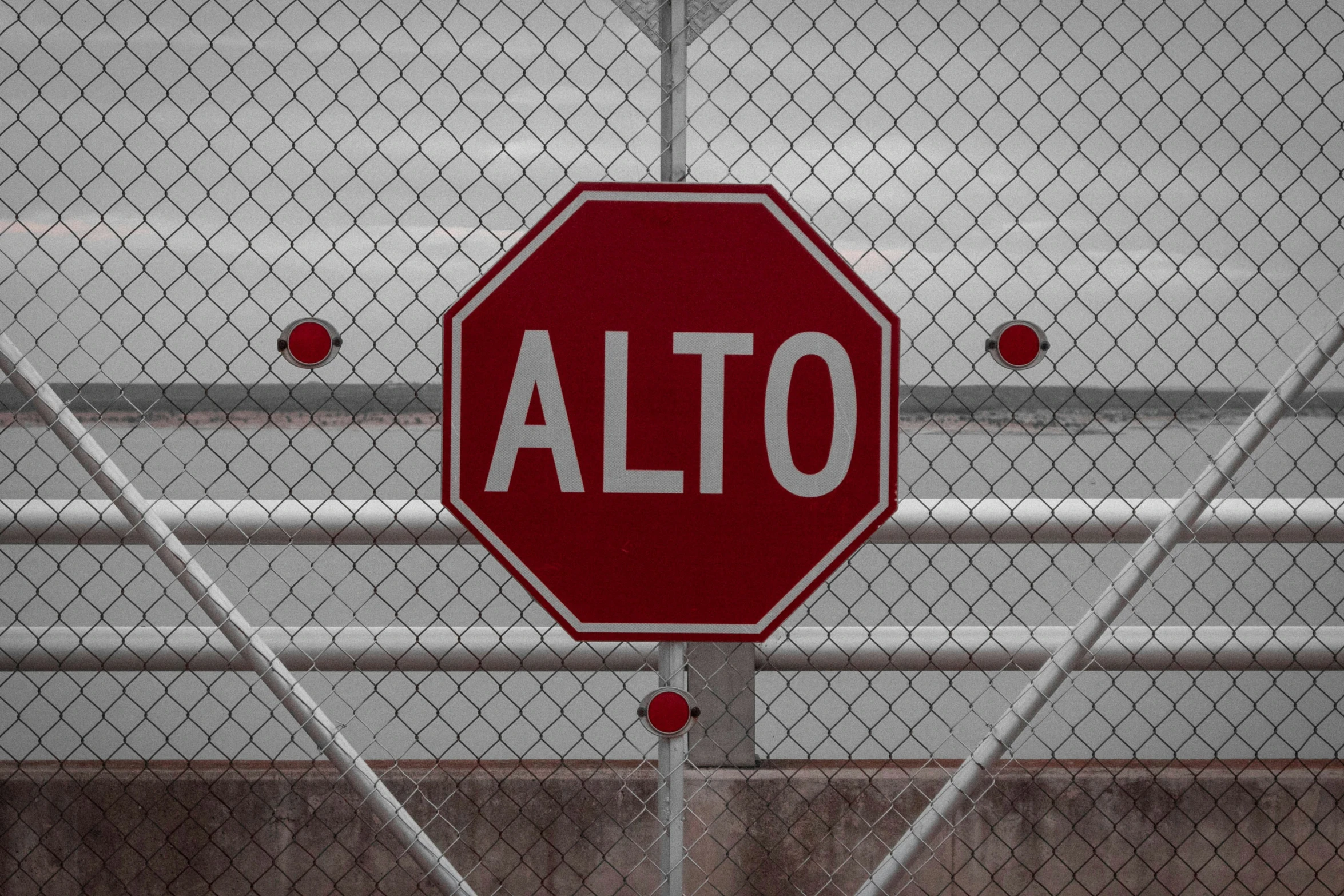 a red stop sign hanging on a fence