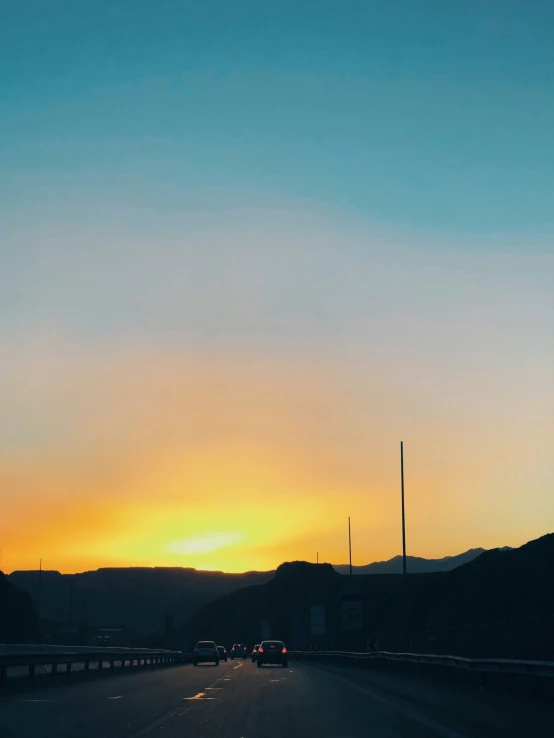 a very long highway during a beautiful sunset