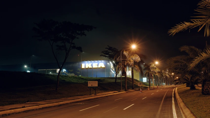 dark po of empty street with lit palm trees