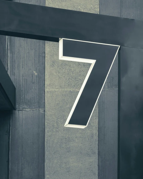 a metal number seven sitting on the side of a building