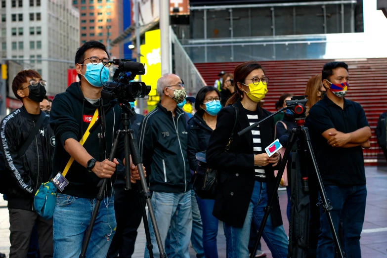 a group of people standing on the street with face masks on