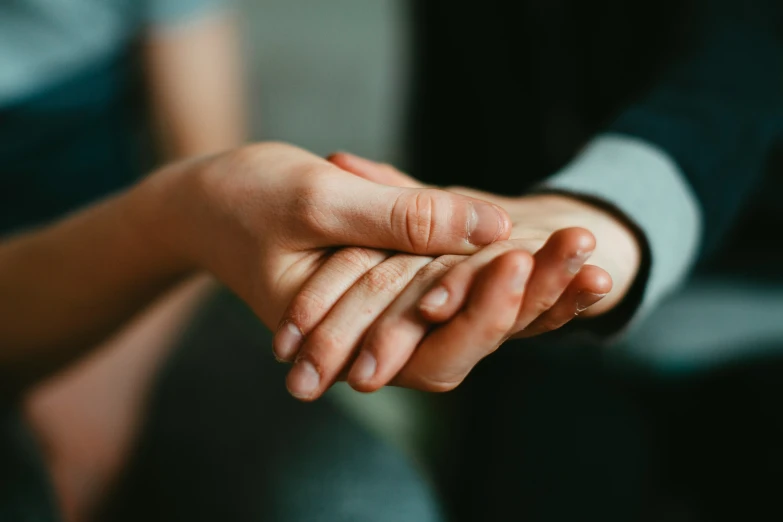 two people hold their hands up while looking off to the side