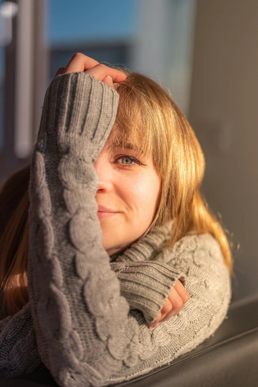 a girl in a grey sweater looking off to her left
