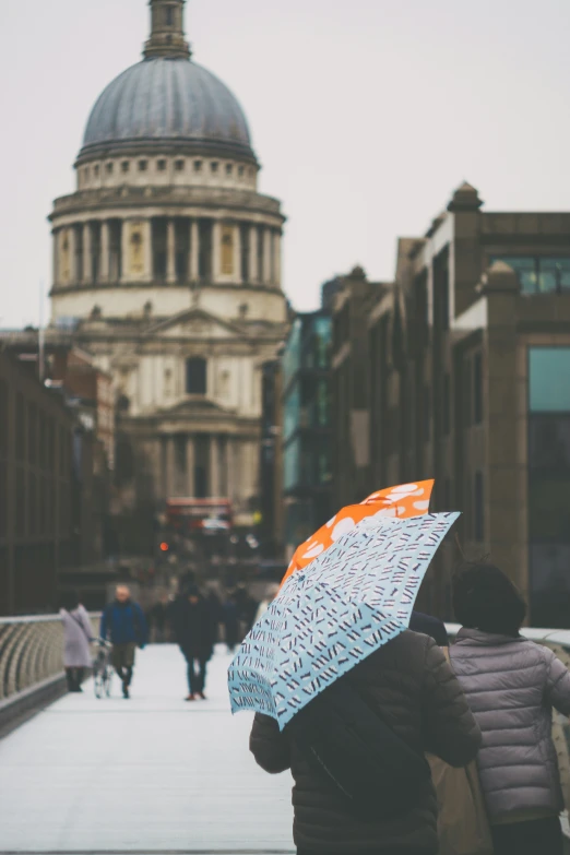 people walking on the sidewalk holding umbrellas