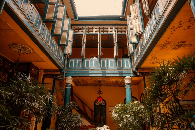 an old building with stairs and plants growing on the balcony