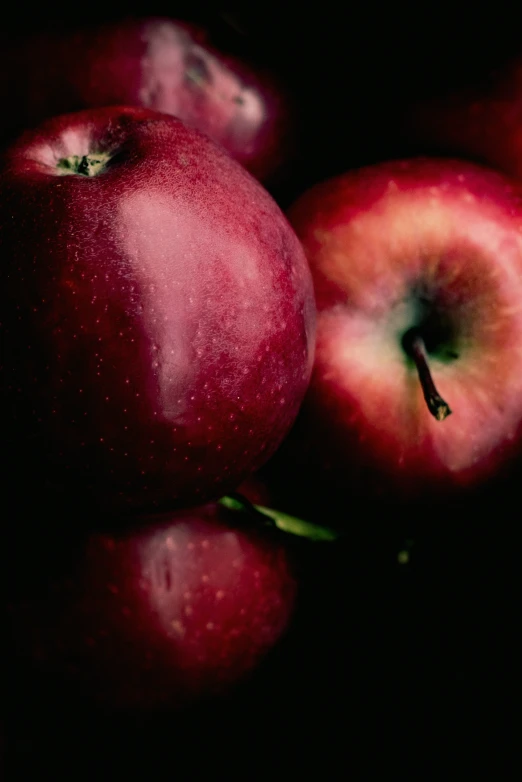 three apples are shown stacked together on the table